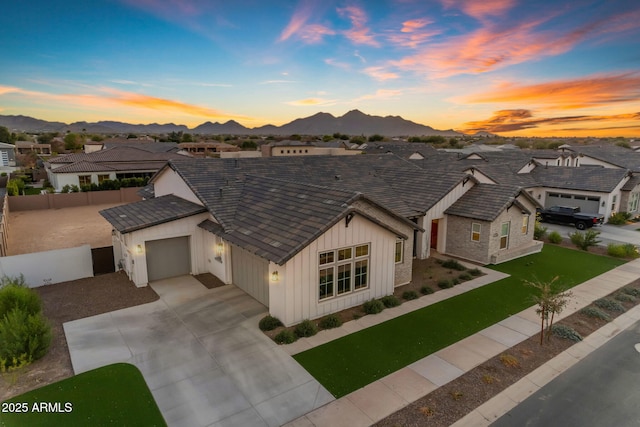 view of front facade with a garage, a lawn, and a mountain view