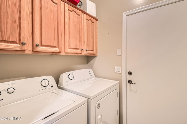 clothes washing area with cabinets and washer and dryer