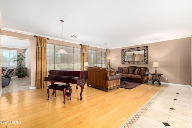 living area featuring ornamental molding, visible vents, light wood-style floors, and baseboards