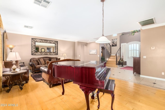 living area featuring stairway, visible vents, and light wood-style floors