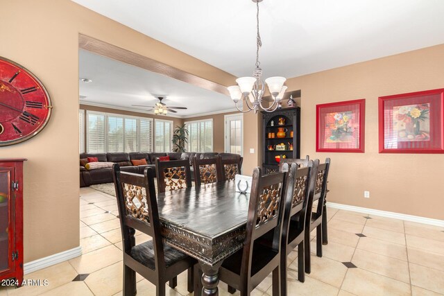 dining area with light tile patterned floors, crown molding, ceiling fan with notable chandelier, and baseboards