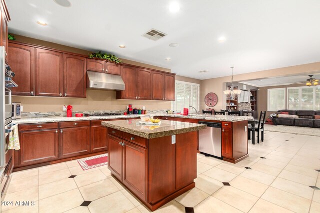 kitchen featuring visible vents, a kitchen island, appliances with stainless steel finishes, a peninsula, and under cabinet range hood