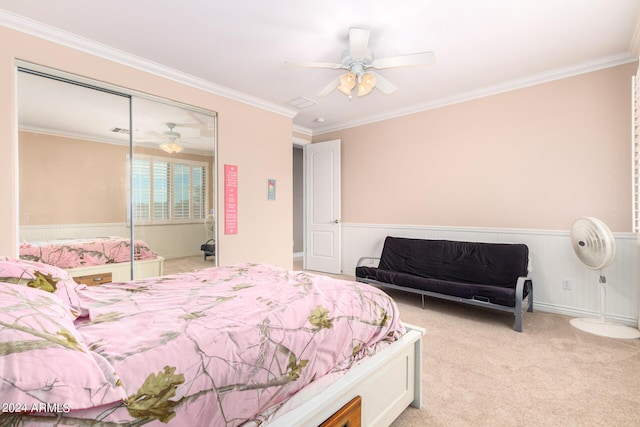 bedroom featuring a ceiling fan, ornamental molding, a closet, and light colored carpet