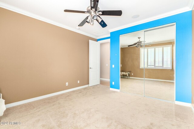 unfurnished bedroom with carpet floors, a closet, crown molding, and baseboards