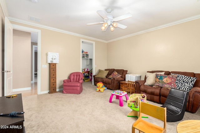 carpeted living room with ornamental molding, visible vents, baseboards, and a ceiling fan