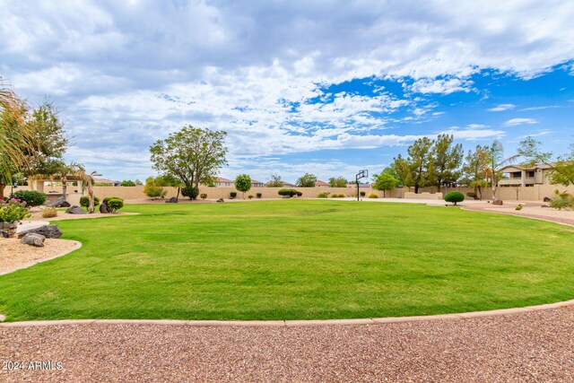 view of property's community featuring fence and a lawn