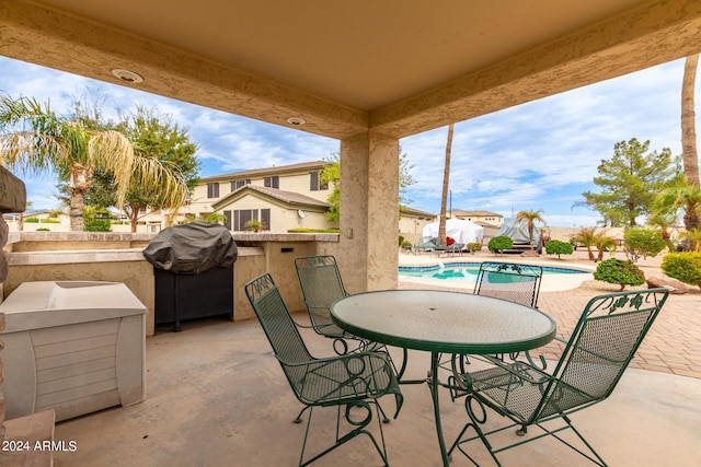 view of patio with an outdoor pool and grilling area