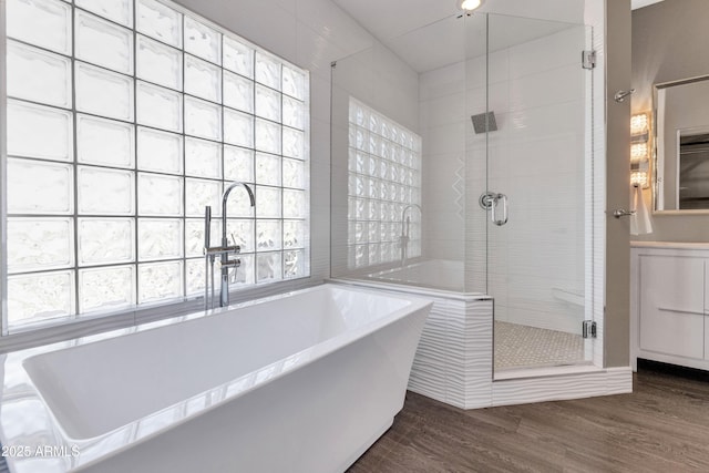 bathroom with independent shower and bath and wood-type flooring