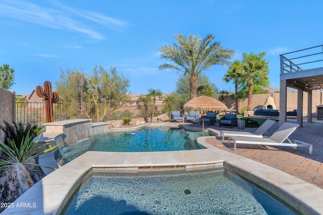 view of swimming pool with an in ground hot tub, pool water feature, an outdoor hangout area, and a patio area