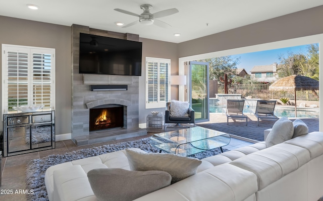 living room featuring ceiling fan and a fireplace