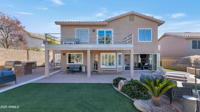 rear view of property with a patio area, area for grilling, a balcony, a lawn, and an outdoor living space