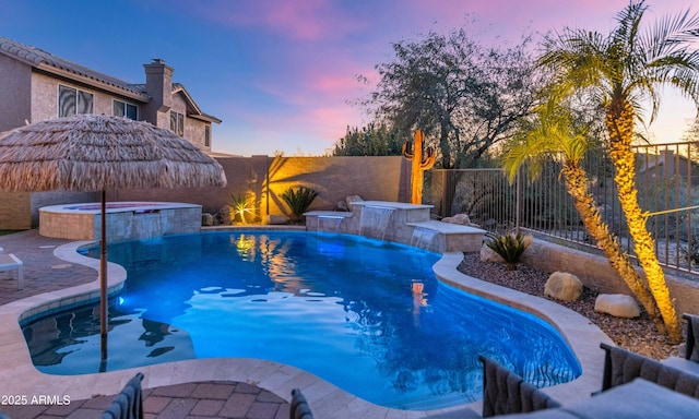 pool at dusk with an in ground hot tub and pool water feature