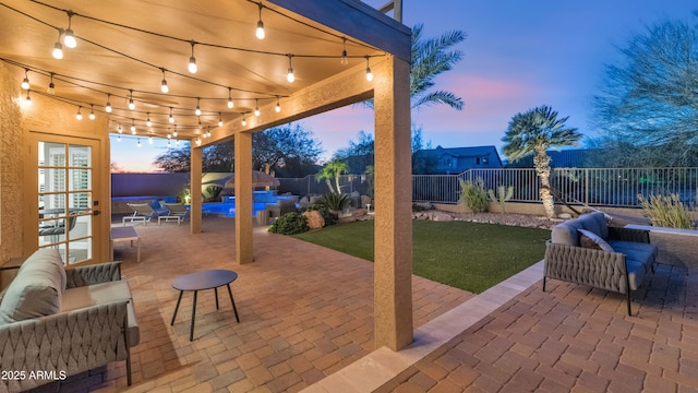 patio terrace at dusk featuring an outdoor living space and a lawn