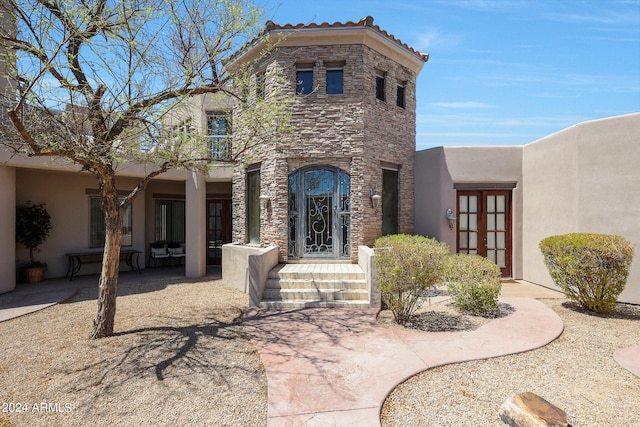 view of front of home featuring a patio, a balcony, and french doors