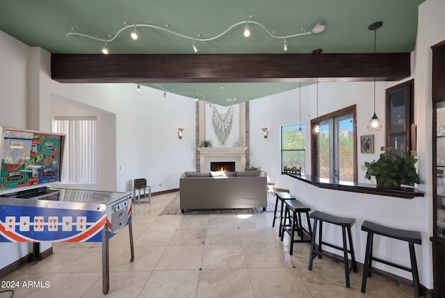 kitchen featuring tile patterned flooring, pendant lighting, and beamed ceiling