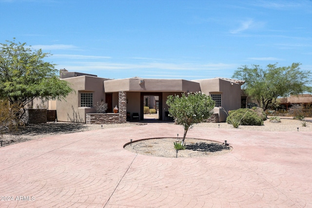 pueblo-style home featuring a patio