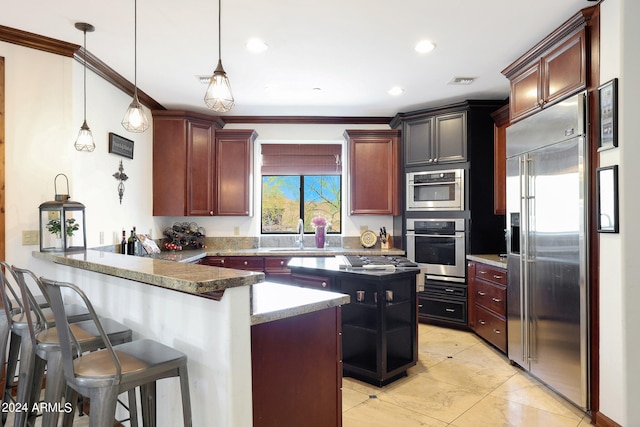 kitchen with decorative light fixtures, a breakfast bar, stainless steel appliances, kitchen peninsula, and dark stone counters