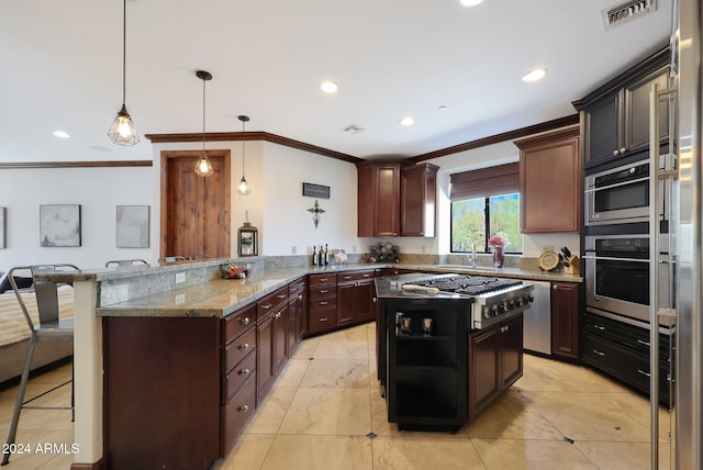 kitchen with hanging light fixtures, appliances with stainless steel finishes, light stone countertops, kitchen peninsula, and a kitchen breakfast bar