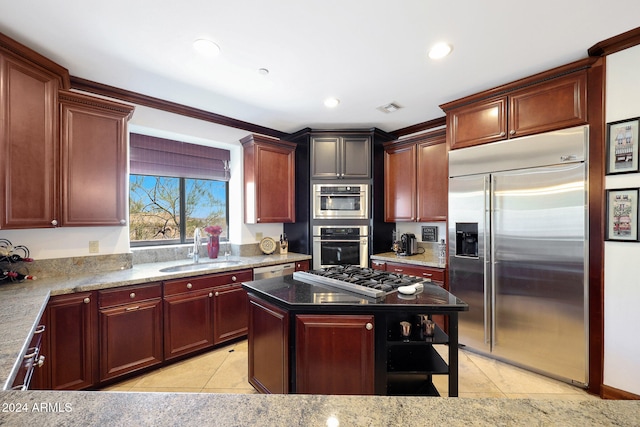 kitchen with light tile patterned floors, a kitchen island, stainless steel appliances, and sink