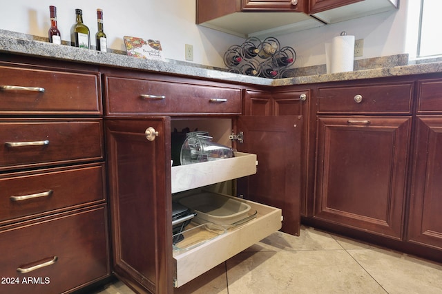 interior space with light tile patterned floors and light stone countertops