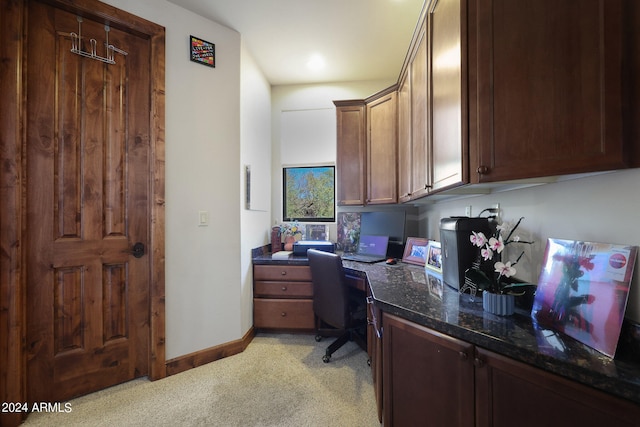 carpeted home office featuring built in desk