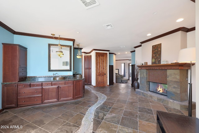 interior space featuring a fireplace, ornamental molding, and vanity