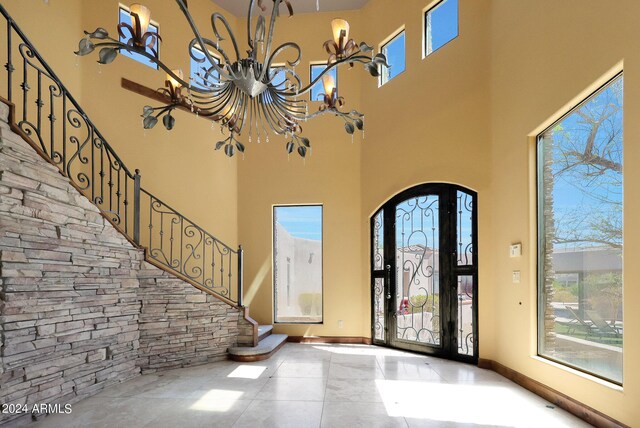 entryway featuring a notable chandelier and a towering ceiling