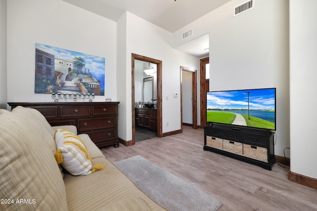 bedroom featuring ensuite bath and light hardwood / wood-style floors