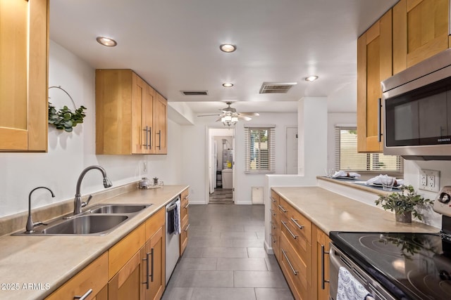 kitchen with visible vents, stainless steel appliances, light countertops, and a sink