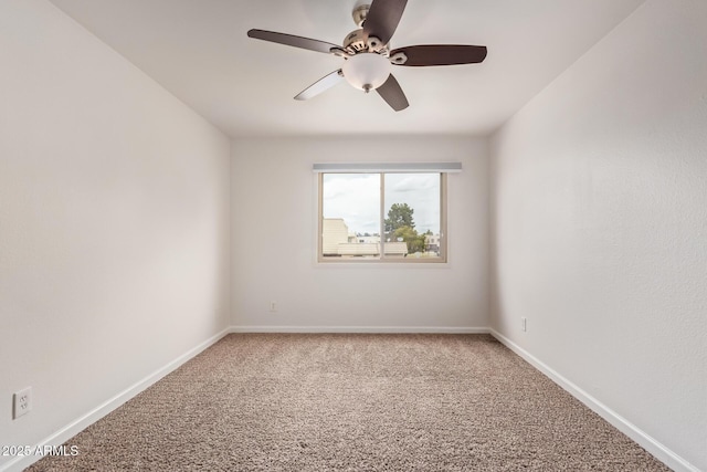 carpeted empty room featuring baseboards and ceiling fan