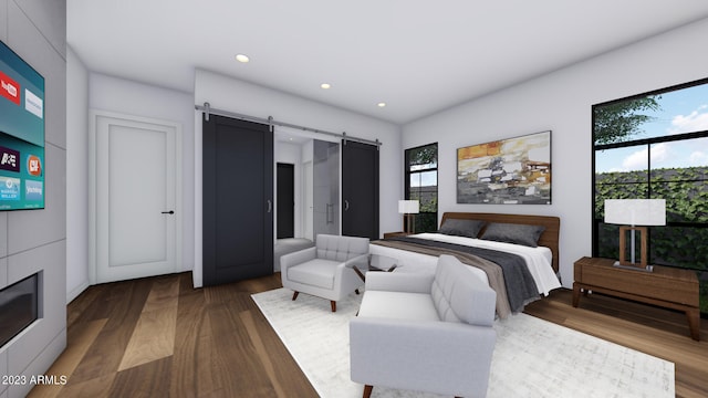 bedroom featuring a barn door and dark hardwood / wood-style flooring