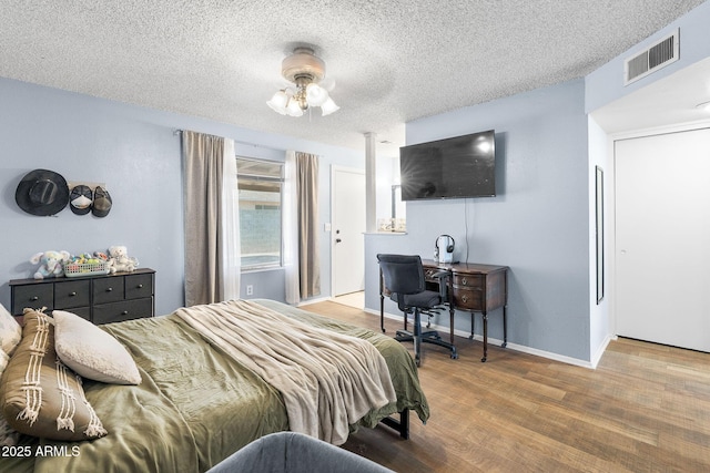 4631 N 77th Dr, Phoenix, AZ 85033 - bedroom with baseboards, a textured ceiling, visible vents, and wood finished floors