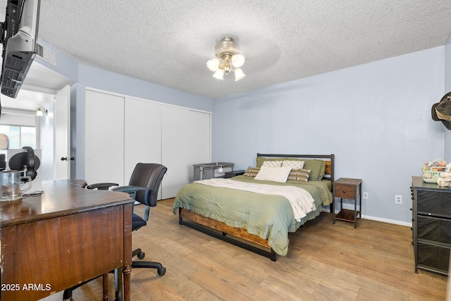 4631 N 77th Dr, Phoenix, AZ 85033 - bedroom featuring a textured ceiling, baseboards, a closet, and wood finished floors