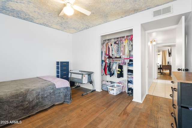 4631 N 77th Dr, Phoenix, AZ 85033 - bedroom featuring ceiling fan, visible vents, wood finished floors, and a closet