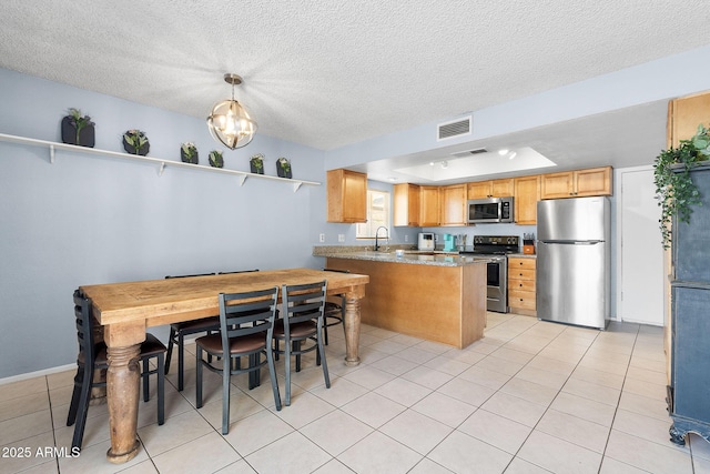 4631 N 77th Dr, Phoenix, AZ 85033 - kitchen with a peninsula, appliances with stainless steel finishes, a sink, and visible vents