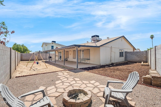 4631 N 77th Dr, Phoenix, AZ 85033 - rear view of property with a fenced backyard, a patio area, a fire pit, and a playground