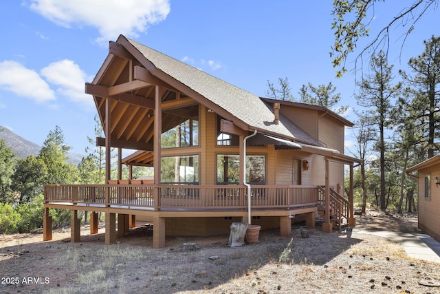 rear view of house with a deck with mountain view