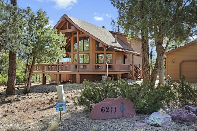 rear view of property featuring a wooden deck