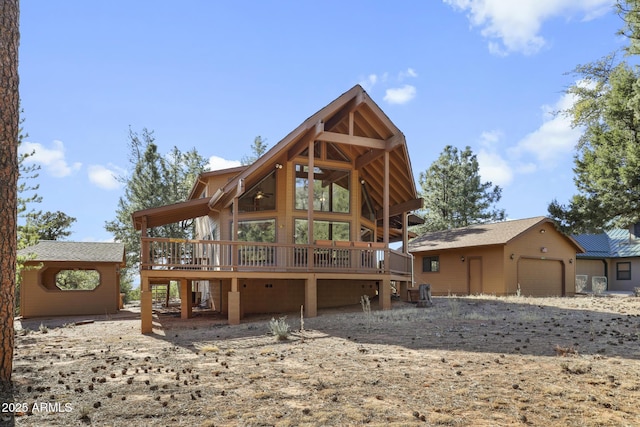 rear view of property featuring a garage and a deck