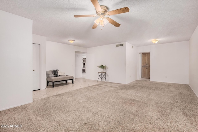 2956 E Concho Ave, Mesa, AZ 85204 - spare room featuring a ceiling fan, carpet flooring, a textured ceiling, and tile patterned floors