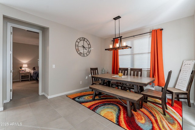 dining room with a chandelier, baseboards, and light tile patterned floors