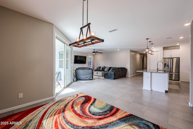 living area featuring light tile patterned floors, ceiling fan, recessed lighting, and baseboards