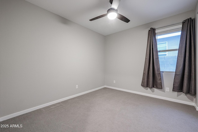 spare room with carpet, a ceiling fan, and baseboards