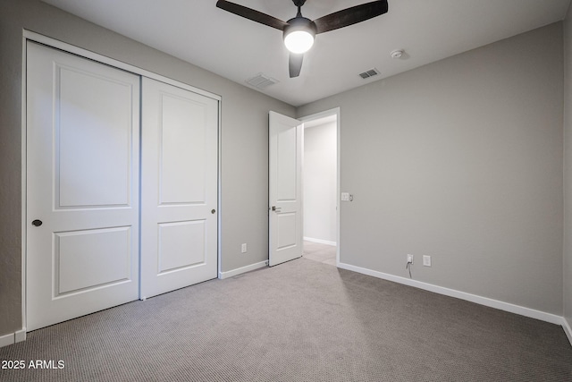 unfurnished bedroom with carpet floors, a closet, visible vents, and baseboards