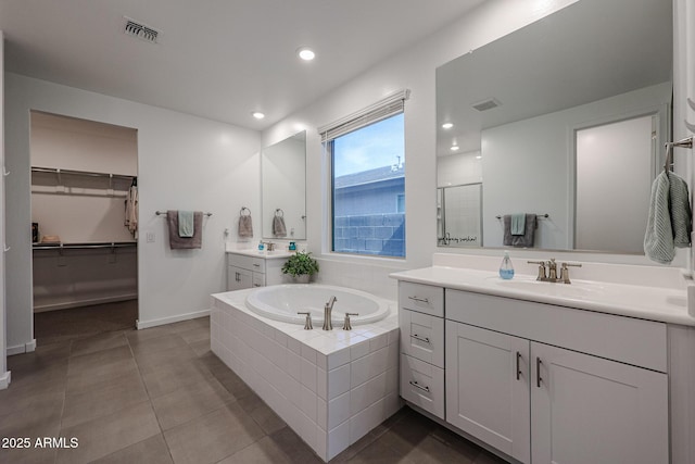 full bath featuring a sink, two vanities, visible vents, and a bath