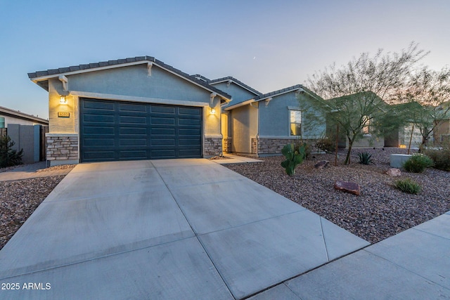 view of front of house with a garage, stone siding, driveway, and stucco siding