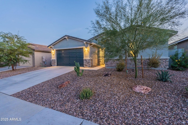 view of front of home featuring stone siding, an attached garage, driveway, and stucco siding