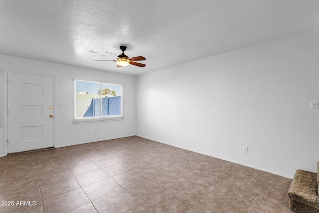 empty room with ceiling fan and a textured ceiling