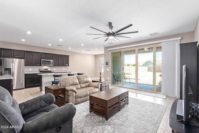 living room featuring ceiling fan, light tile patterned flooring, and sink