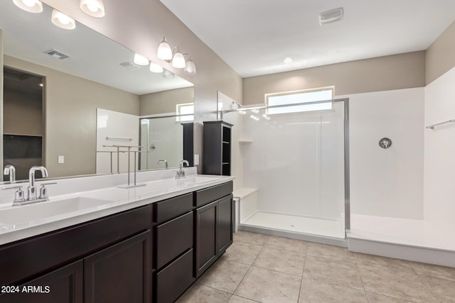 bathroom featuring vanity, tile patterned flooring, and a shower